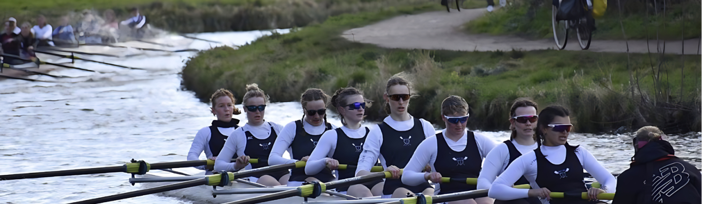 Boat club rowing on river