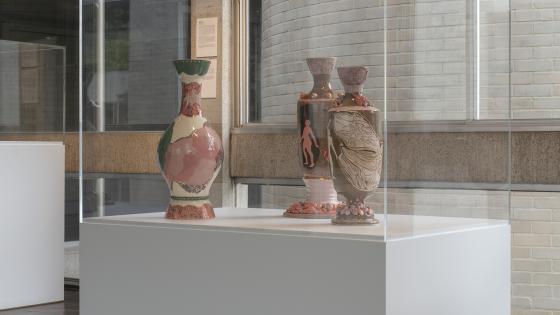 A photo of three ceramics in a glass vitrine