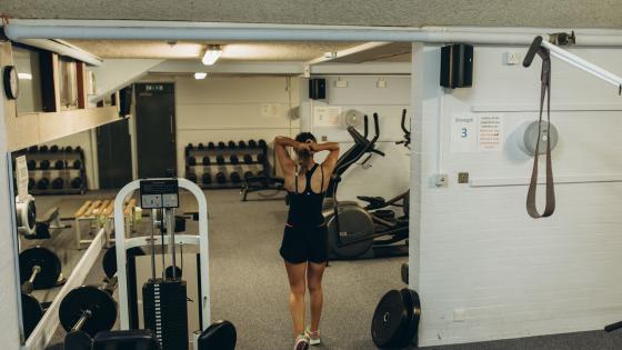 Student putting her hair up in college gym