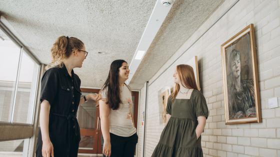 Three students chatting in the President's Corridor