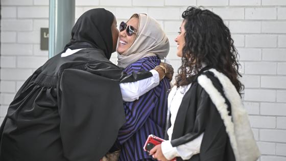 Three women in academic gowns hugging