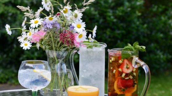 Silver table in garden with jug of Pimm's with glasses and vase of flowers